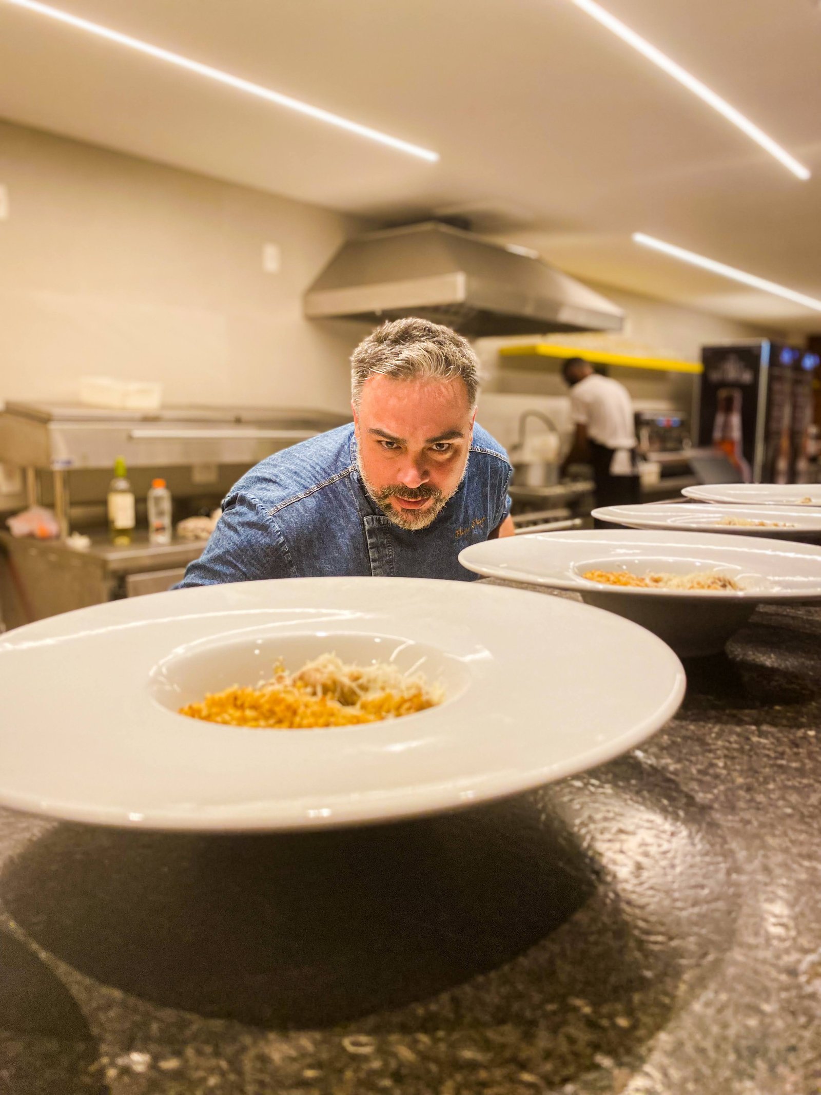 Flavio Flarys finalizando pratos em uma cozinha profissional