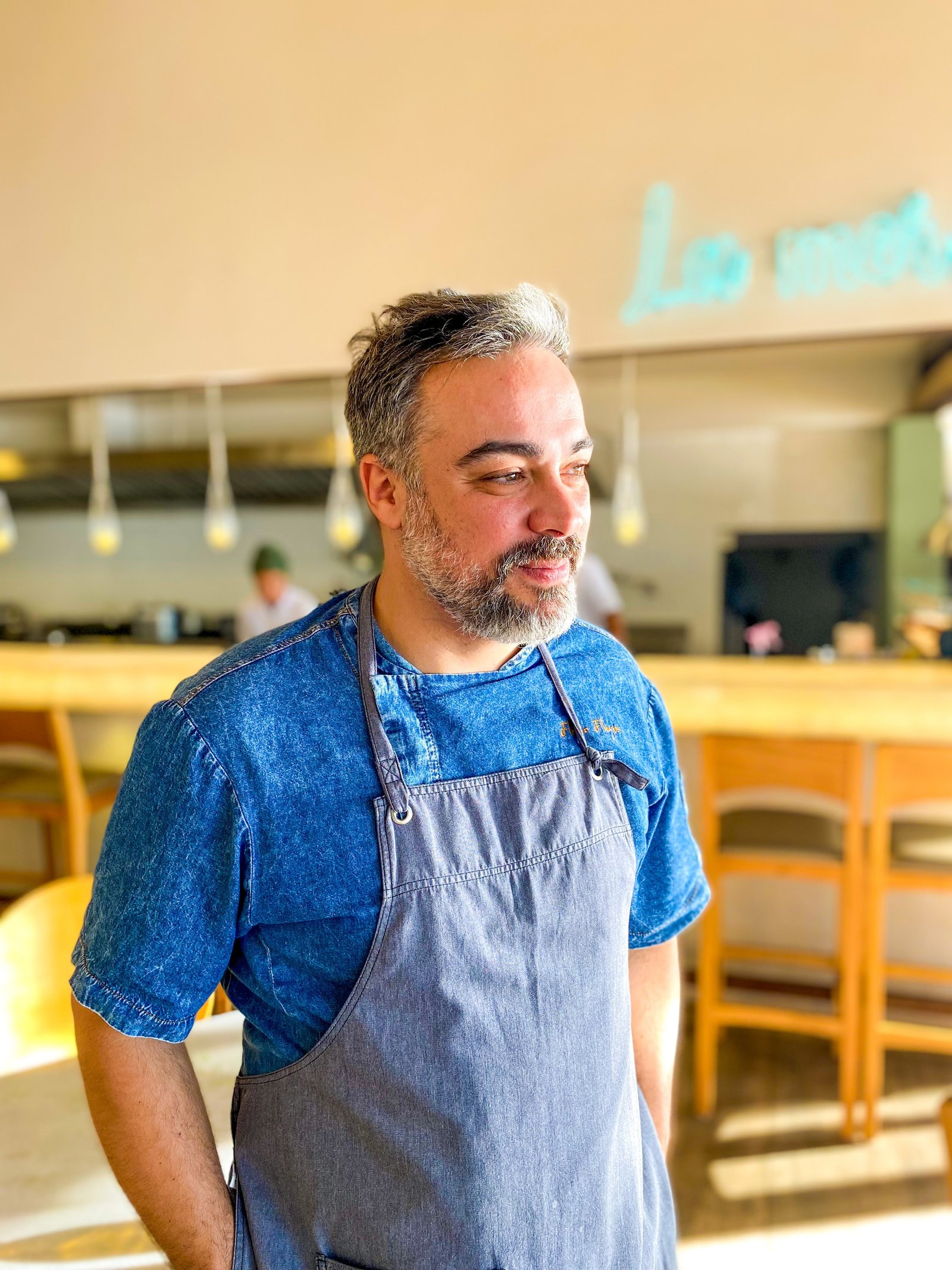 Flavio Flarys com dolman e avental em uma cozinha profissional